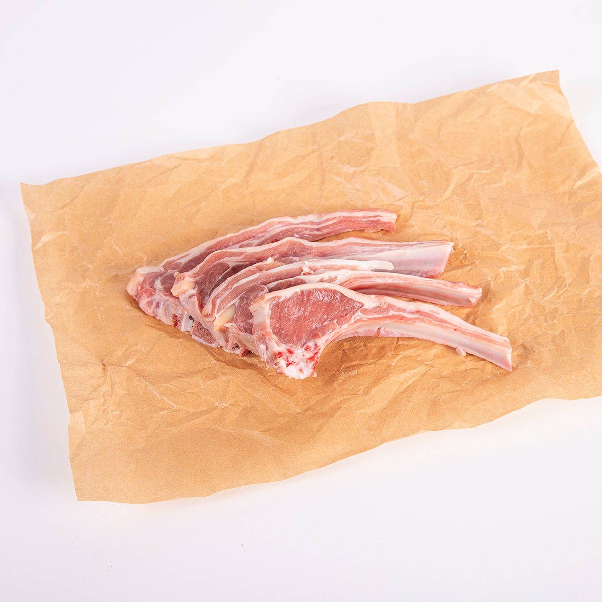 tres chuletas frescas de cordero extremeño sobre papel