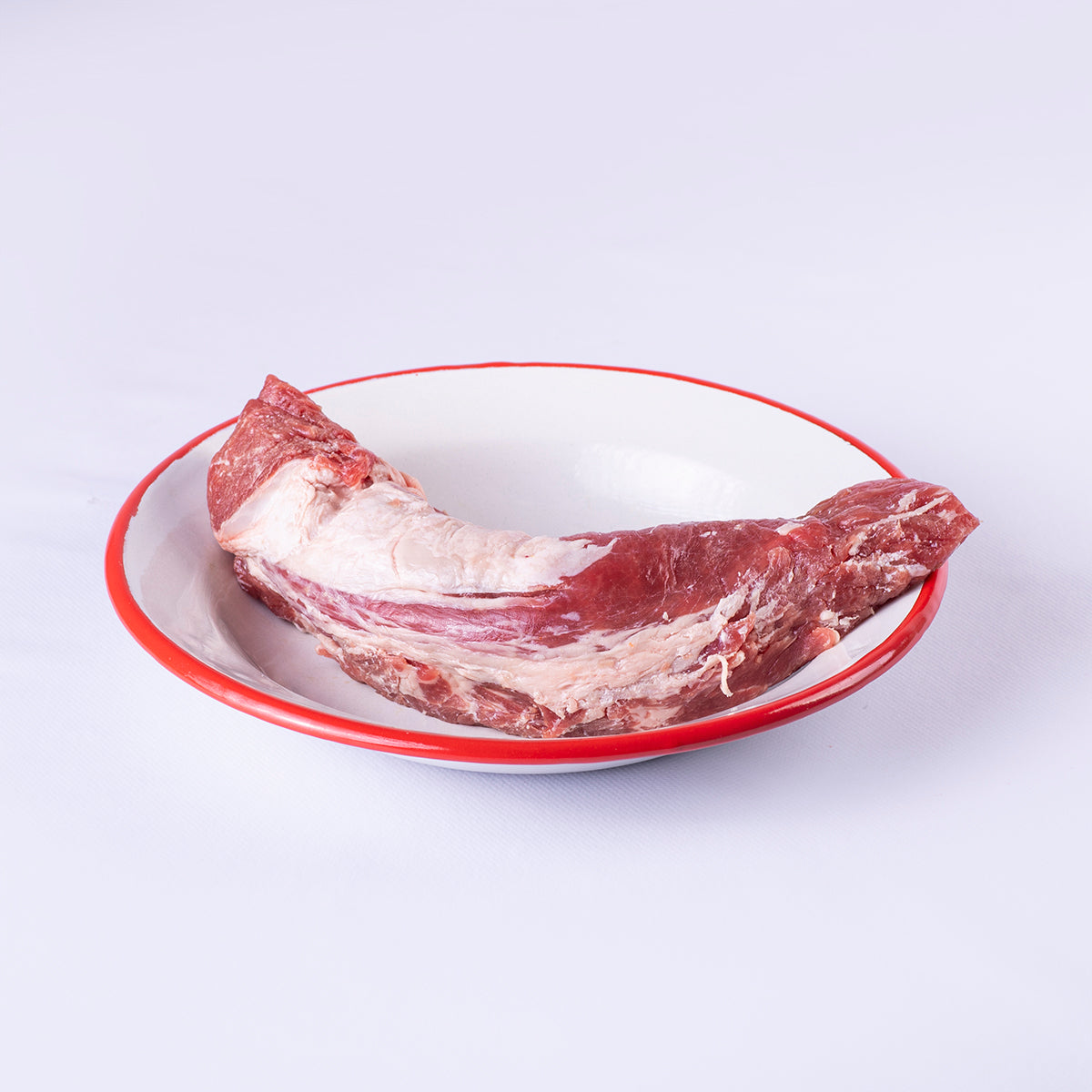 solomillo iberico extremeño sobre plato blanco con filo rojo